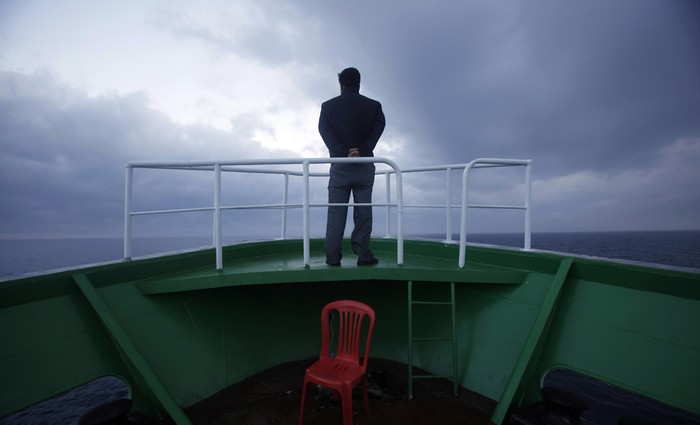 . Một người đàn ông đứng trên mũi tàu Mangyongbyong nhìn về phía núi Kumgang.